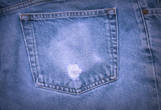 A Worn and tattered blue Jeans pocket