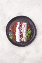 Sandwiches, herring fish, on dark rye bread, sprinkled with onion, chili pepper and herbs, on a
