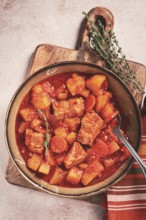Meat goulash with potatoes and carrots, sweet peppers, in a saucepan, top view, traditional