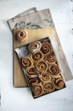Freshly baked cinnamon rolls on a wooden board