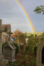 Rainbow over the heritage-protected cemetery near St. Marien Church, Lüdersen mountain village,