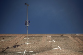 The frog-eye view transforms a paved parking lot in Cologne into a steep wall against a deep blue