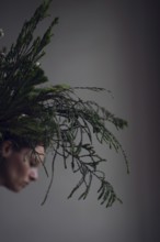 Head of woman behind ostrich with grasses