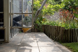 Legs sticking out of a window, garden view