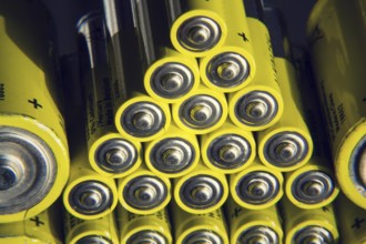 Yellow double A batteries reflecting in mirror, electricity storage concept