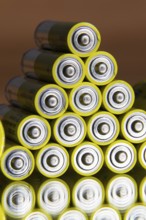 Stack of yellow AA batteries close up abstract coloured background
