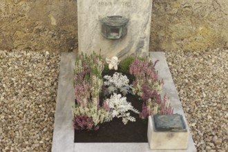 Children's grave with angel figure and beautiful flower decoration for All Saints on a cemetery
