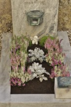 Children's grave with angel figure and beautiful flower decoration for All Saints on a cemetery
