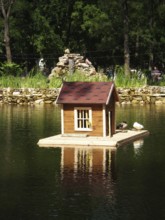 Pond with bird house on the backdrop of an alphine slide in Gorky Park. One of the well-known