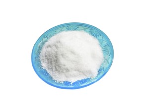 Stylish green salt shaker with patterns with a heap of salt on a white background