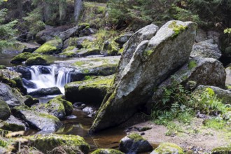 A stream flows over large, moss-covered stones and creates a peaceful atmosphere, Höllfall