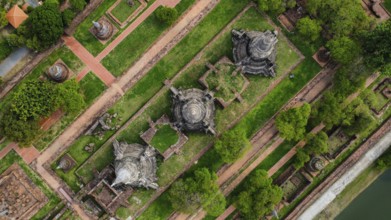 An ancient temple complex next to a city and a modern temple, in Thailand, seen from above