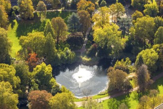 Aerial view, fountain and lake in backlight in city garden with autumn trees, Südviertel, Essen,