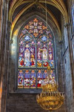 Colourful window and candelabra in the neo-gothic votive church, Vienna, Austria