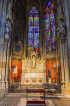 The altar and colorful windows in the neo-gothic votive church, Vienna, Austria