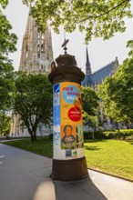 Advertising column, in the back the church towers of the Votive Church, Vienna, Austria