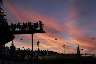 Visitors sit at sunset on the terrace of a cafe in the Urania am Danube Canal, Urania Observatory,