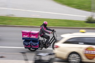 Quick delivery service bike, passes by taxis, at Düsseldorf-Bilk railway station, taxi stand, North
