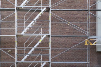 Borken, NRW, Germany, RScaffolding structure standing against a red brick wall for construction or