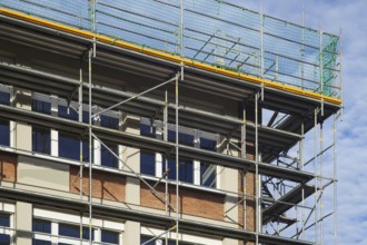 Borken, NRW, Germany, RBuilding renovation site showing scaffolding and protective nets against a