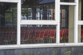 Borken, NRW, Germany, REmpty red chairs filling an auditorium, visible through window panes