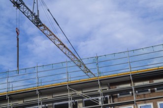 Borken, NRW, Germany, RConstruction crane and scaffolding against a blue sky, renovating a building
