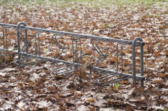 Borken, NRW, Germany, REmpty metal bike rack standing in a park surrounded by dry brown autumn