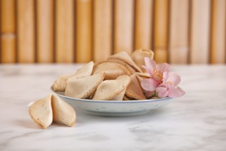 Fortune cookies in a Chinese bowl with a pink flower