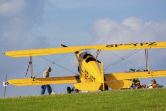 A Bücker Bü 131 Jungmann biplane parked at the edge of the airfield, SP-YPZ registration, as part