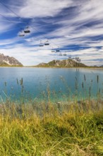 The panoramic lake on Saloberkopf with cable car and mountains in the background under a blue sky,