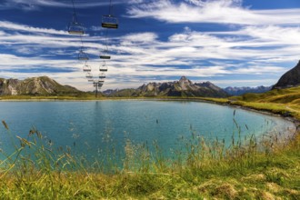The panoramic lake on Saloberkopf with cable car and mountains in the background under a blue sky,