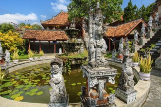 Guardian figures in front of an old well in Brahma Vihara Arama Buddha Banjar Buddhist monastery,