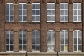 Symmetrical façade of an old brick building with large industrial windows, former Germania cotton