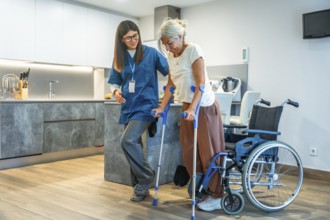 Professional caregiver helping an older woman with crutches, safely supporting her during a