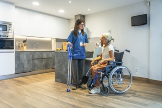 Professional caregiver providing home assistance to a senior woman in a wheelchair, discussing her