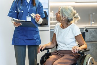 Healthcare professional wearing blue scrubs holding a clipboard and blister pack, explaining