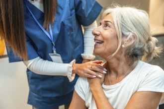 Healthcare worker in scrubs providing comforting support to a smiling senior woman, symbolizing