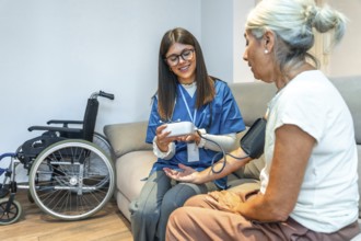 Healthcare professional checking blood pressure for an elderly patient while providing medical