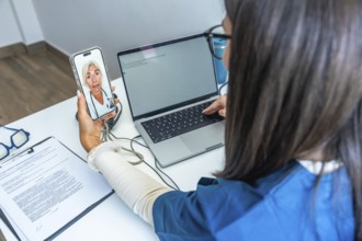 Healthcare professional having a video conference with a doctor on a smartphone while using a