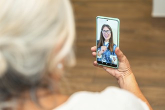 Senior woman is using a smartphone for an online medical consultation, receiving virtual healthcare