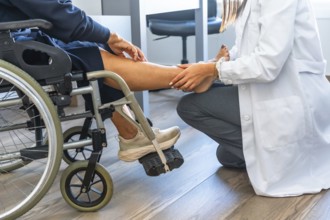Healthcare professional examining a patient's leg and foot while the patient is sitting in a