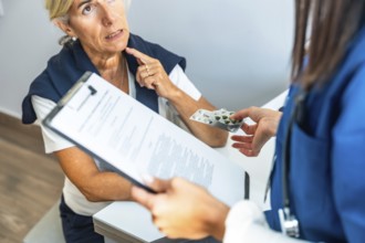Medical professional discussing treatment options and handing blister pack of pills to an elderly