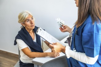 Healthcare professional explaining medication to an attentive elderly patient during annual check