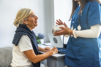 Healthcare professional in blue scrubs holding a blood pressure monitor, explaining its use to an