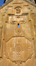 Detailed view of an artistic stone relief work with religious symbols on a church wall, Noravank
