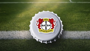 Bottle cap featuring the Bayer Leverkusen logo placed on a football field, representing team pride