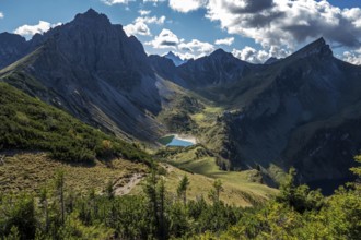 View from the Sallfelder Höhenweg hiking trail to Lache See and mountains of the Allgäu Alps, left