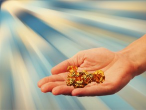 Symbolic photo, hand with gold nugget, stable value, risks, crash or upswing, financial economy,