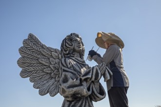 Chandler, Minnesota, Artist Primi Monteiga re-paints her concrete sculpture of an angel in the