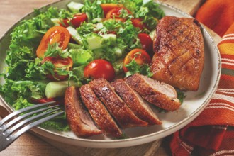Delicious grilled duck breast served with fresh garden salad and cherry tomatoes at a rustic dining